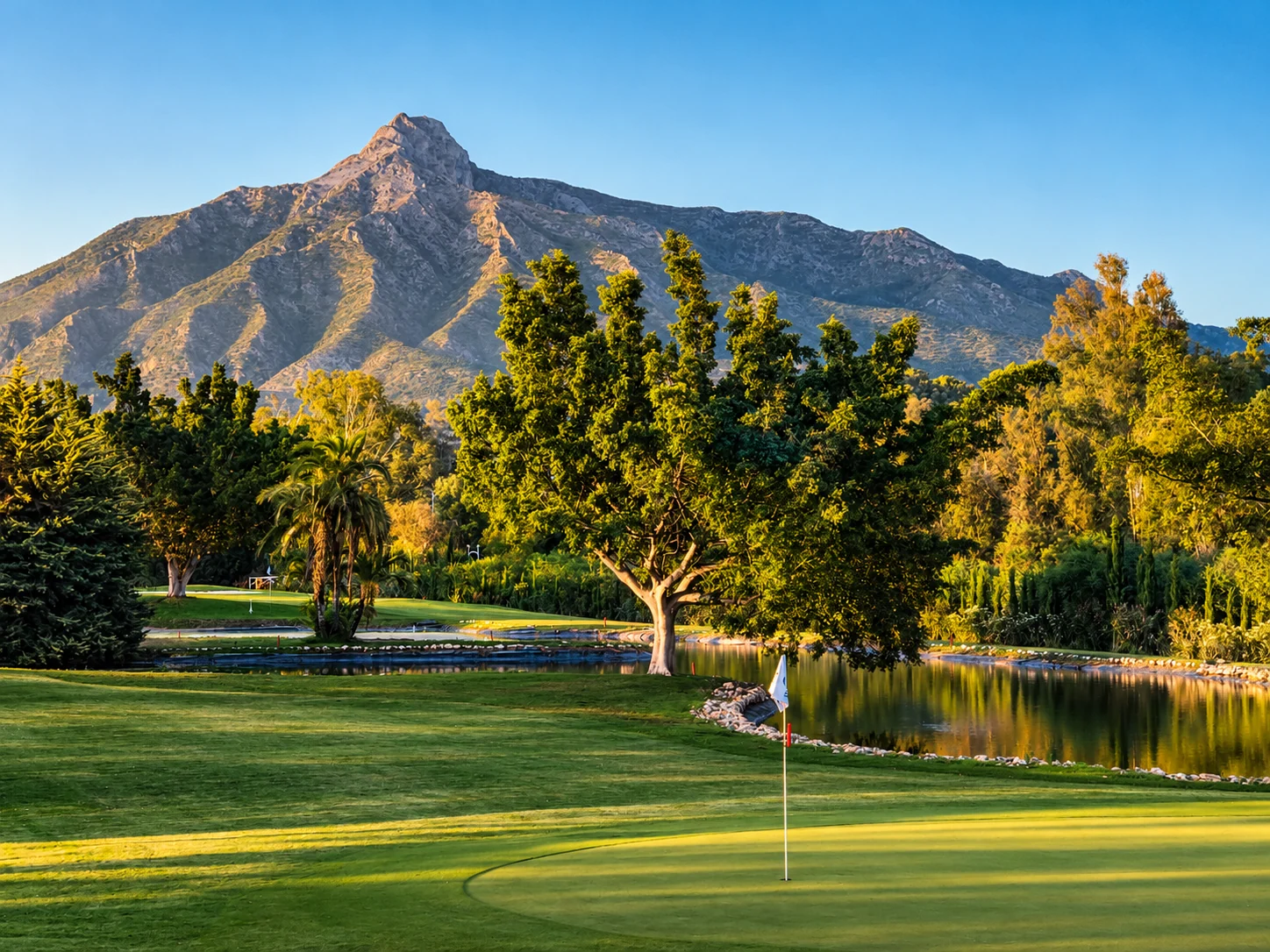 Illustrative BANÚS golf-course landscape; not a photograph of a specific practice facility